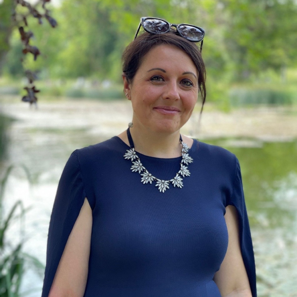 Sarah, wearing blue dress with sunglasses on head